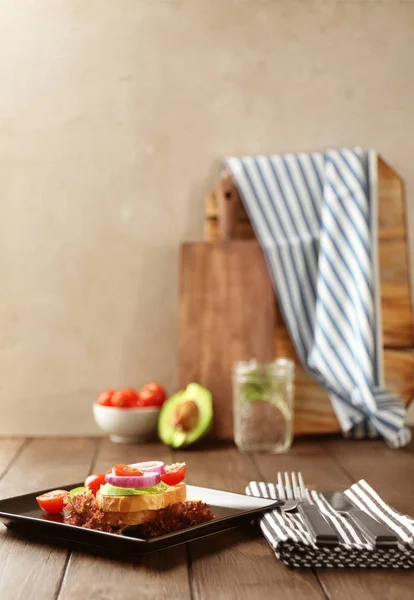 Placa con delicioso sándwich en la mesa —  Fotos de Stock