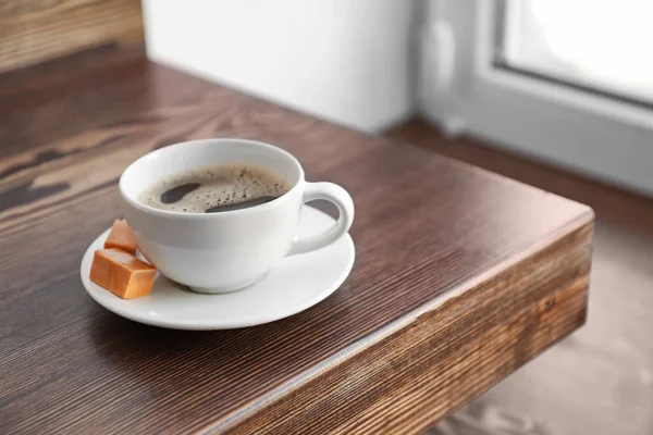 Kopje koffie op de teller in de buurt van vensterbank — Stockfoto