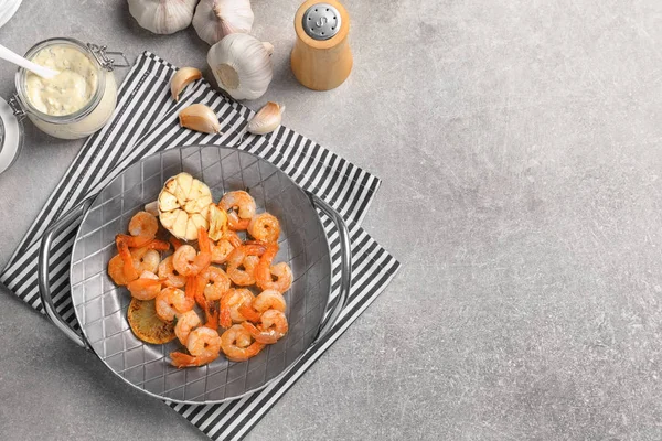 Dish with delicious fried shrimps and garlic on table