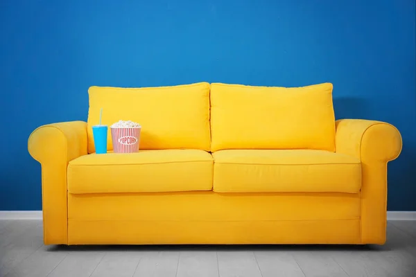 Žlutá pohovka s popcorn a nápoje v domácí kino. Sledování filmu — Stock fotografie