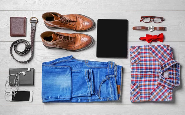 Set of hipster clothes on wooden floor, flat lay — Stock Photo, Image