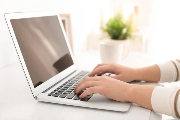 Giovane donna che lavora con il computer portatile moderno a tavola, primo piano — Foto Stock