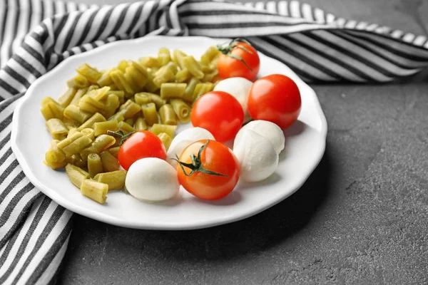 Πιάτο Κονσερβοποιημένα Πράσινα Φασόλια Ντομάτες Και Μοτσαρέλα Στο Τραπέζι — Φωτογραφία Αρχείου