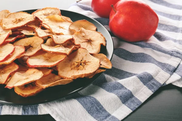 Tallrik med välsmakande äpple chips på bordet — Stockfoto