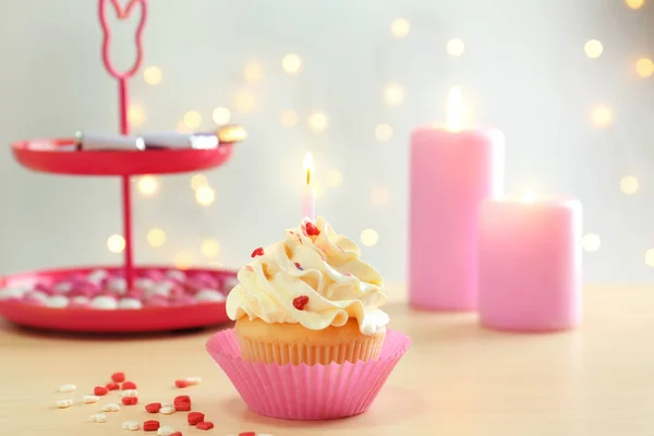 Bolo de aniversário com vela na mesa contra fundo borrado — Fotografia de Stock