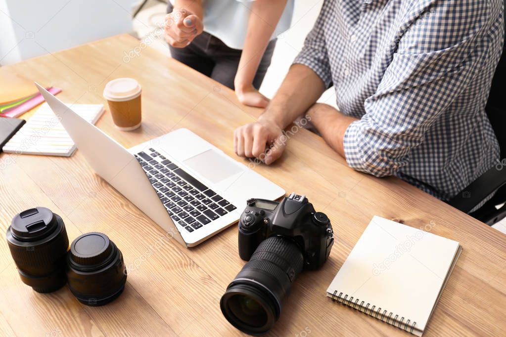 Photographers with laptop in office