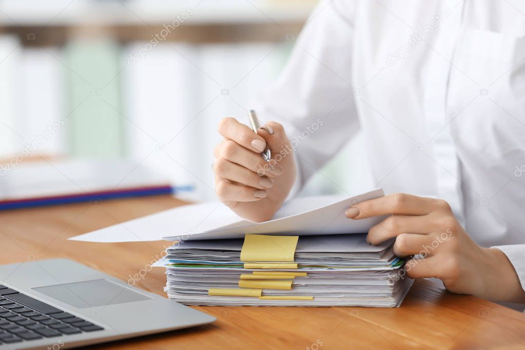 Young woman working with documents in office, closeup