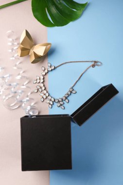 Hediye kutusu, kolye ve renk arka plan, üstten görünüm üzerinde flamalar açıldı