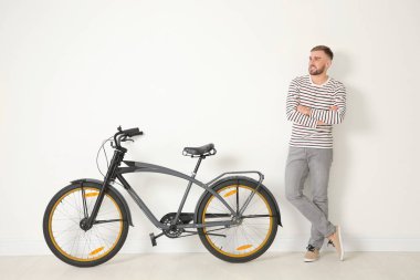 Yakışıklı genç hipster adam Bisiklet ışık duvarının yakınında ile