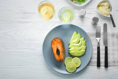 Lezzetli kızarmış alabalık avokado, kireç ve ahşap masa, üstten görünüm sosu ile