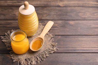 Cam Kavanoz ve kaşık bal ahşap arka plan üzerinde