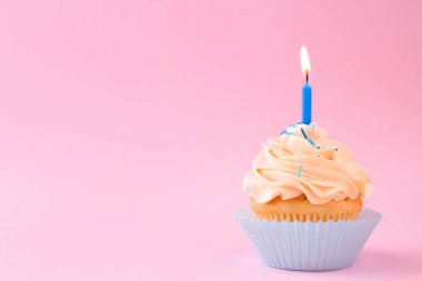 Renkli arkaplanda mum olan lezzetli bir kek.