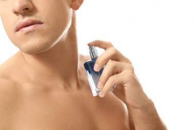 Beyaz arka planda parfüm şişesi olan yakışıklı adam, yakın plan.