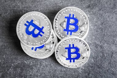 Koyu gri arka plan üzerinde gümüş bitcoins
