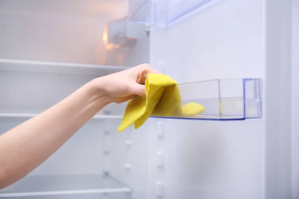 Женщина чистит холодильник тряпкой, крупным планом — стоковое фото
