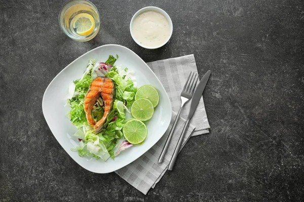 Heerlijk gebakken regenboogforel met salade en saus op grijze achtergrond, bovenaanzicht — Stockfoto