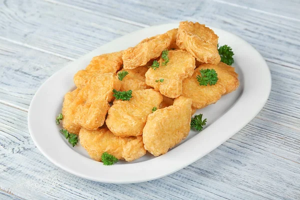 Prato com nuggets de frango saborosos na mesa — Fotografia de Stock
