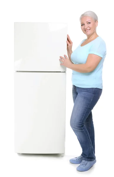 Rijpe vrouw stond in de buurt van de koelkast op witte achtergrond — Stockfoto