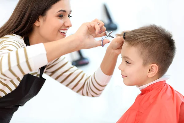 Peluquería femenina trabajando con un niño pequeño en el salón, primer plano — Foto de Stock