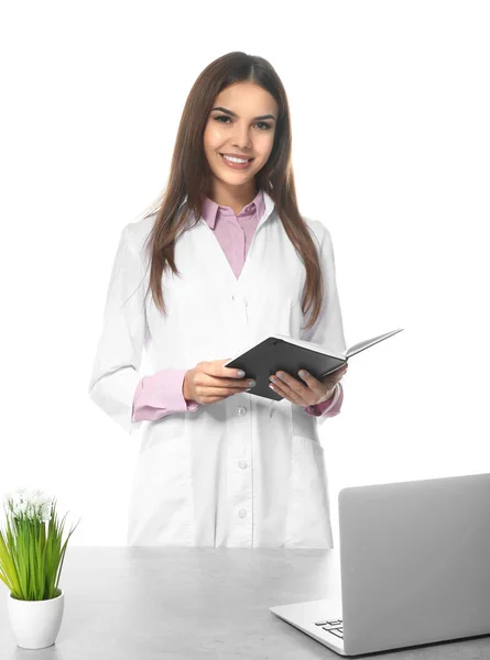 白い背景の上のノートブックで若い女性薬剤師 — ストック写真