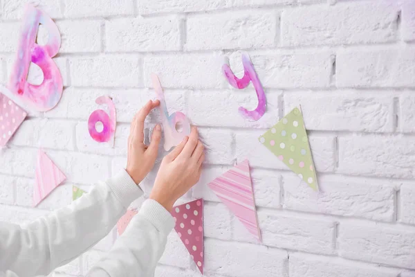 Woman decorating wall for baby shower party indoors — Stock Photo, Image