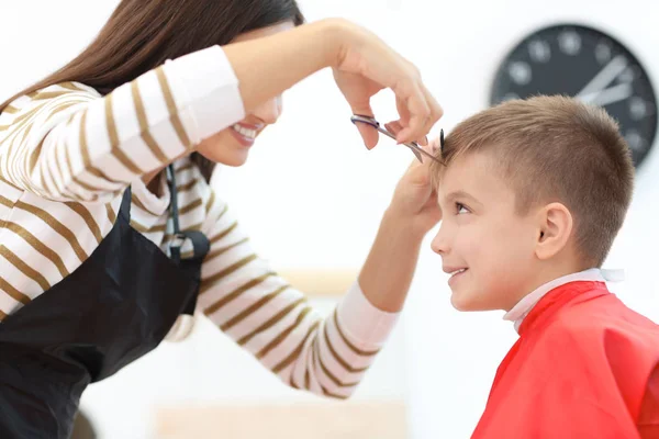 Peluquería femenina trabajando con un niño pequeño en el salón, primer plano — Foto de Stock