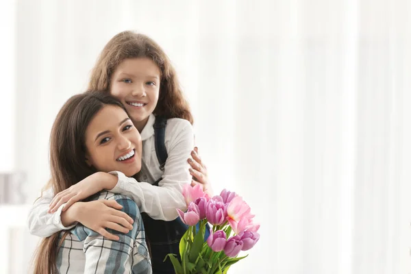 Junge Frau Und Ihre Tochter Mit Tulpenstrauß Drinnen Muttertagsfeier — Stockfoto