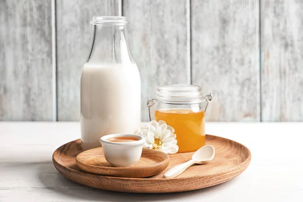 乳と蜜のテーブルの上の木製の皿 — ストック写真
