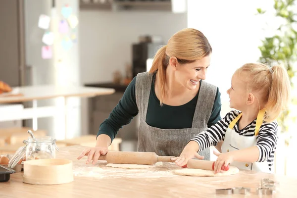 Mãe e filha com massa de farinha à mesa em casa — Fotografia de Stock