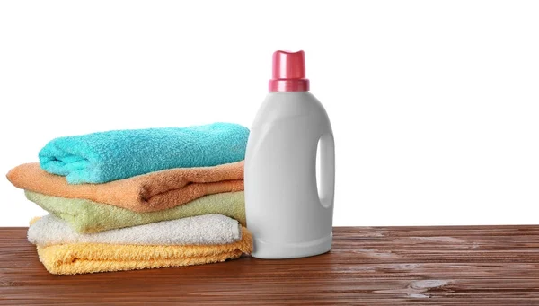 Folded towels and laundry detergent on table against white background — Stock Photo, Image