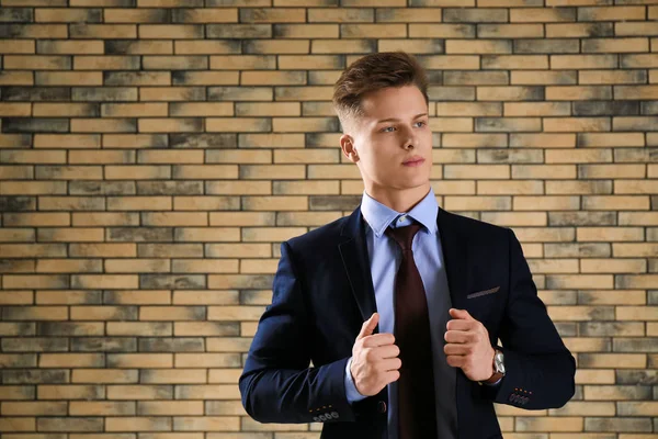 Hombre guapo en traje formal contra la pared de ladrillo —  Fotos de Stock