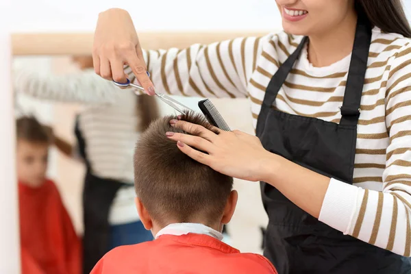 Femme coiffeuse travaillant avec un petit garçon dans le salon, gros plan — Photo