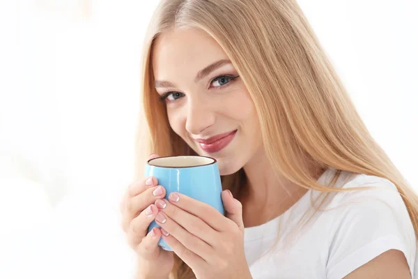 Jovem bela mulher sorridente com xícara de café no fundo branco — Fotografia de Stock