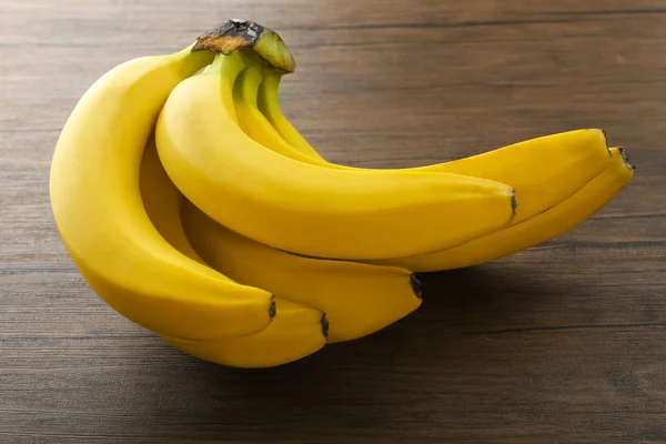 Стиглі банани на дерев'яному фоні — стокове фото