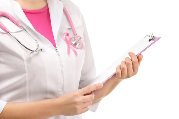 Доктор с розовой лентой на халате и планшете на белом фоне. Концепция информированности о раке груди — стоковое фото