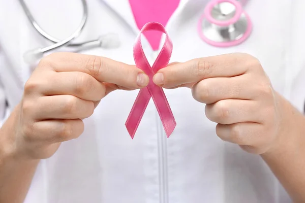 Doctor sosteniendo cinta rosa, primer plano. Concepto de conciencia sobre el cáncer de mama — Foto de Stock