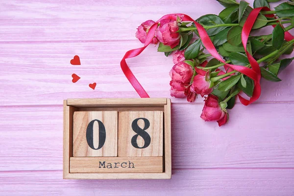 Roses and block calendar on wooden background, top view. Composition for International Women's Day — Stock Photo, Image