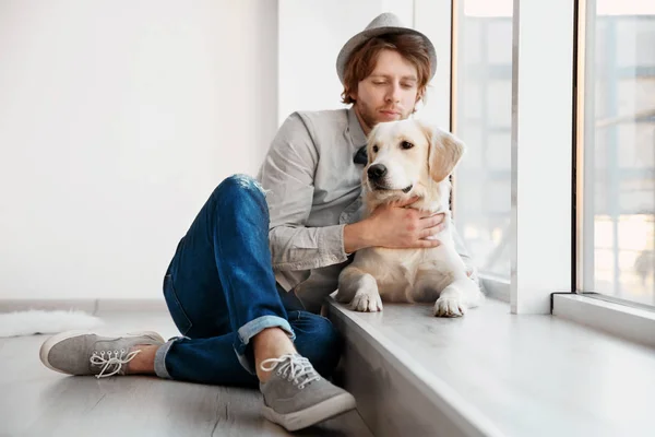 Красивый молодой хипстер с собакой в помещении — стоковое фото