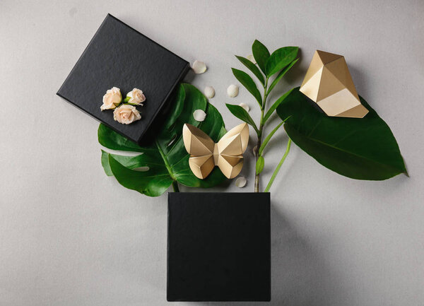 Открытая подарочная коробка, листья и декор на светлом фоне, вид сверху
