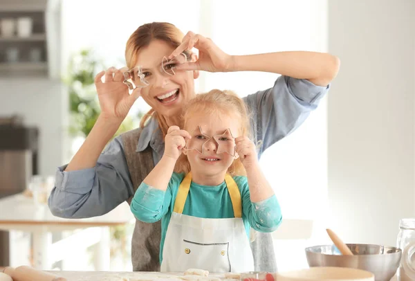 Mother and daughter having fun while  preparing cookies from dough indoors — Stock Photo, Image