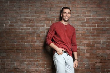 Yakışıklı genç adamın yanında tuğla duvar portresi