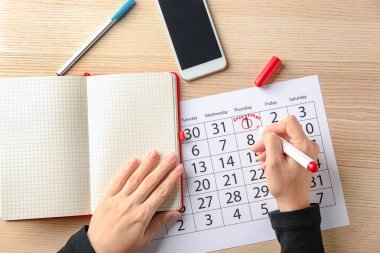 Takvimdeki tarihi işaretleme ve kelime nişan masada yazı kadın