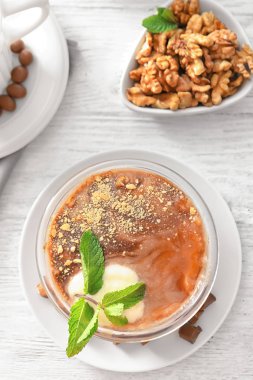 Ahşap masa üzerinde fındık ile nefis karamelli tatlı kase