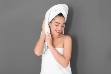 Gri arka plan üzerinde beyaz havlu genç kadın