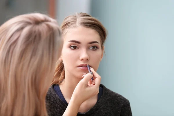 Professionell konstnär att skapa makeup för vackra modell på suddig bakgrund — Stockfoto