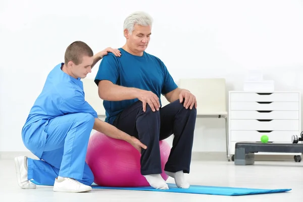 Fisioterapeuta trabalhando com paciente em centro de reabilitação — Fotografia de Stock