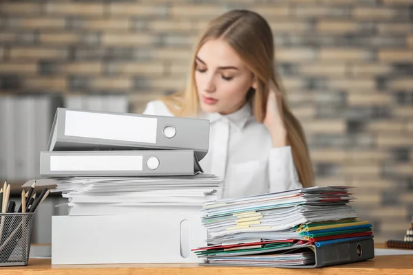 Junge Frau mit Stapel von Dokumenten auf dem Tisch im Büro — Stockfoto