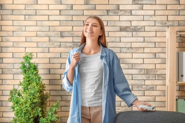 Young woman standing in air conditioned room — Stock Photo, Image