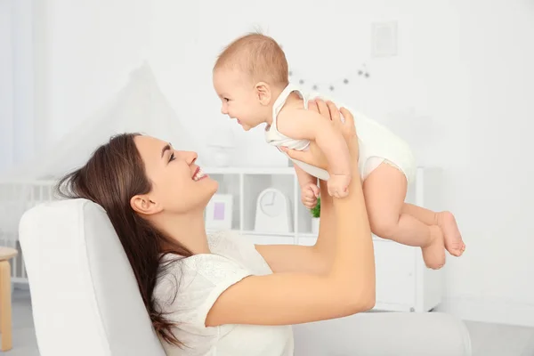 Retrato de una joven madre jugando con un lindo bebé en casa — Foto de Stock
