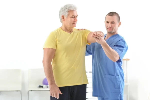 Physiotherapist working with patient in rehabilitation centre — Stock Photo, Image